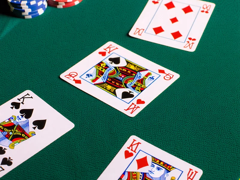 Hình ảnh các bộ bài trong Three Card Poker được sắp xếp trên bàn xanh, thể hiện sự nhanh gọn và hấp dẫn của trò chơi tại J88.